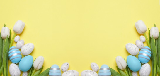 Image of Flat lay composition with decorated Easter eggs and flowers on pale yellow background, space for text. Banner design