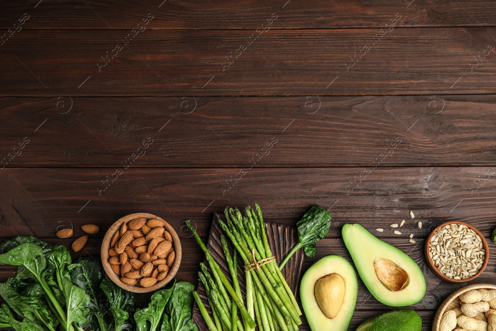 Photo of Different products rich in vitamin E on wooden table, flat lay. Space for text