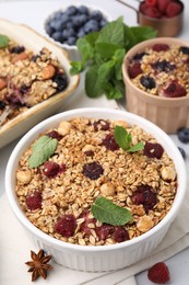 Tasty baked oatmeal with berries, nuts and anise star on table