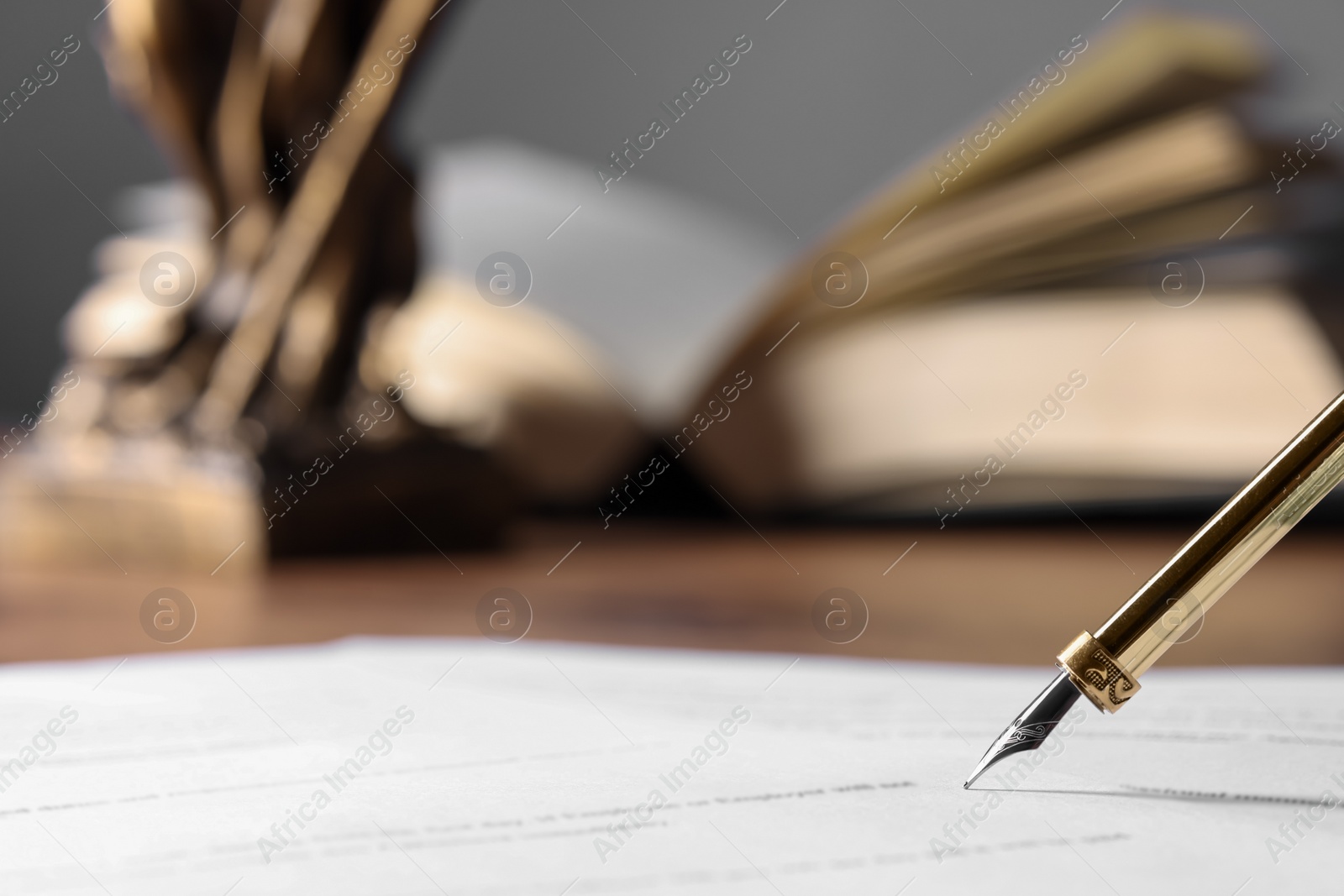 Photo of Writing on document with fountain pen at table, closeup and space for text. Notary contract