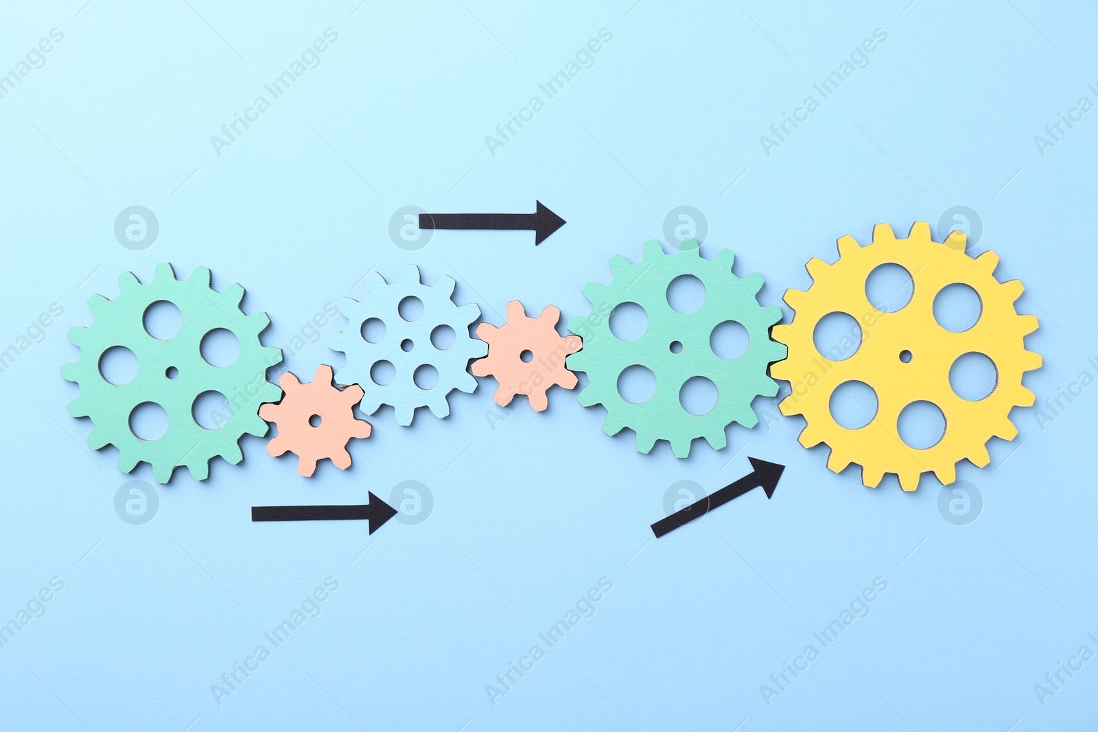 Photo of Business process organization and optimization. Scheme with wooden figures and arrows on light blue background, top view