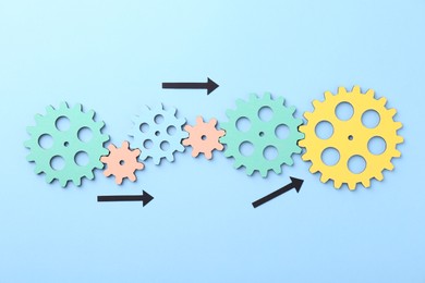 Photo of Business process organization and optimization. Scheme with wooden figures and arrows on light blue background, top view