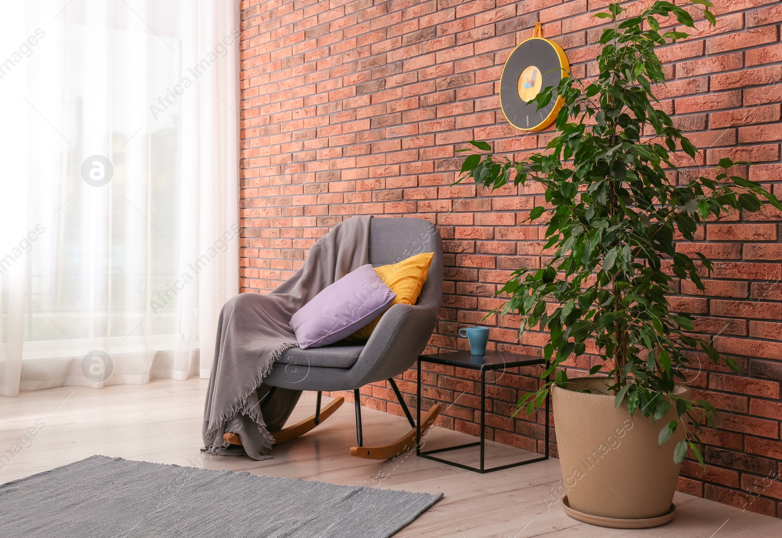 Photo of Stylish room interior with armchair and potted ficus