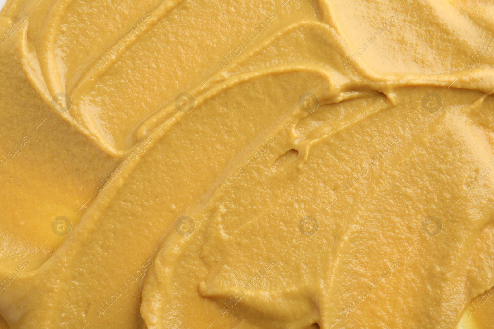 Photo of Fresh tasty mustard sauce as background, top view