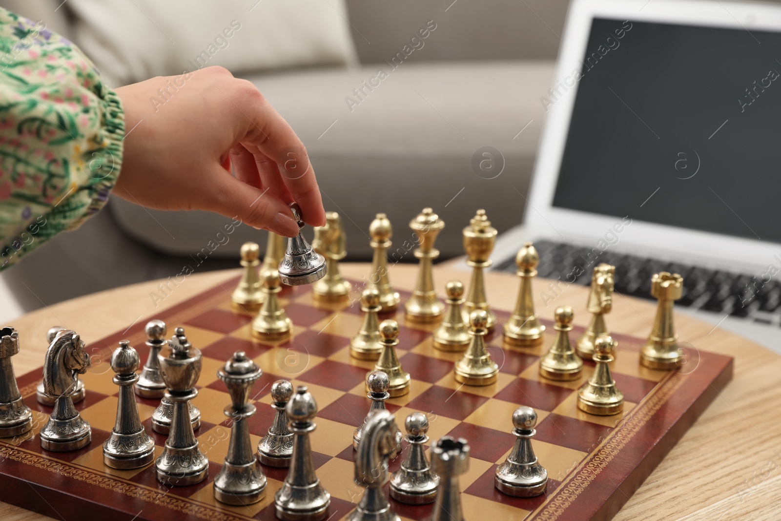 Photo of Woman playing chess with partner through online video chat at home, closeup