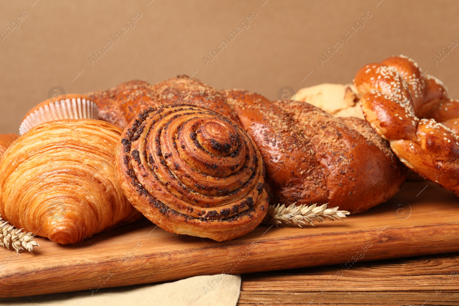 Photo of Different tasty freshly baked pastries on wooden table