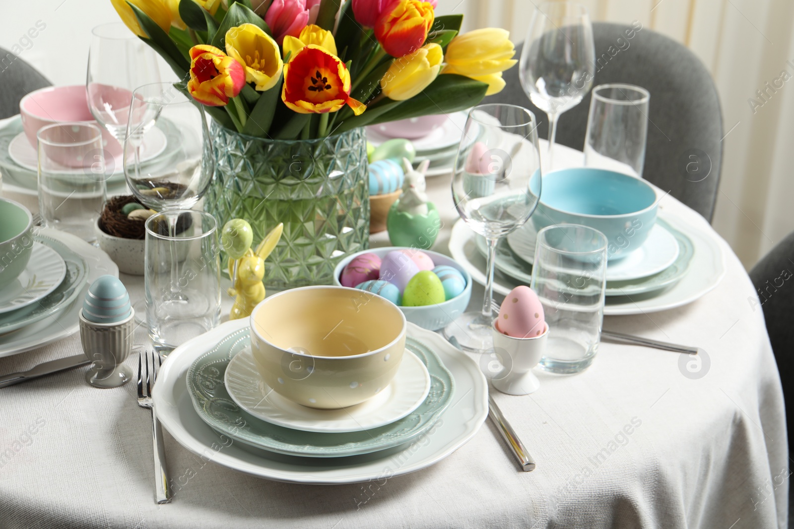 Photo of Easter celebration. Festive table setting with beautiful flowers and painted eggs