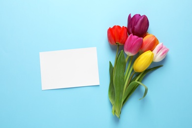 Photo of Bouquet of beautiful spring flowers and blank card on color background, flat lay. Space for text