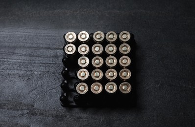 Set of gun bullets on dark table, above view