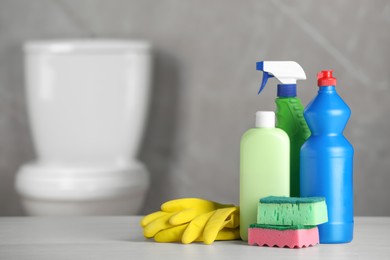 Photo of Cleaning supplies on table in bathroom, space for text