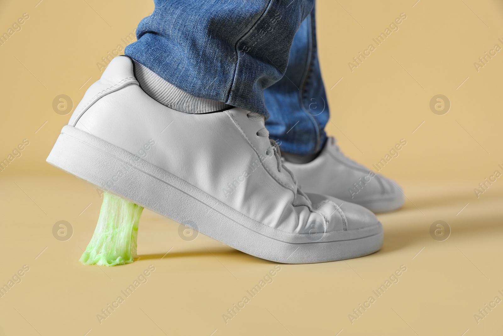 Photo of Person stepping into chewing gum on light brown background, closeup