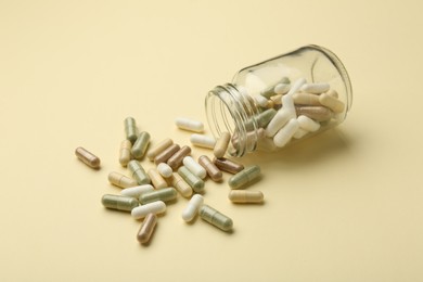 Vitamin pills and bottle on beige background