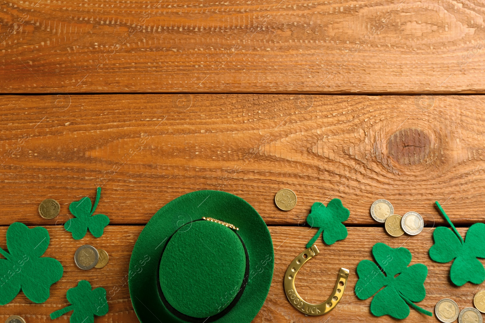 Photo of Leprechaun's hat and St. Patrick's day decor on wooden background, flat lay. Space for text