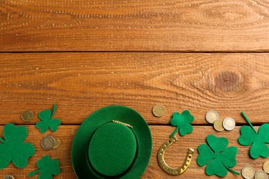 Photo of Leprechaun's hat and St. Patrick's day decor on wooden background, flat lay. Space for text