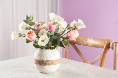 Photo of Vase with beautiful flowers as element of interior design on table in room