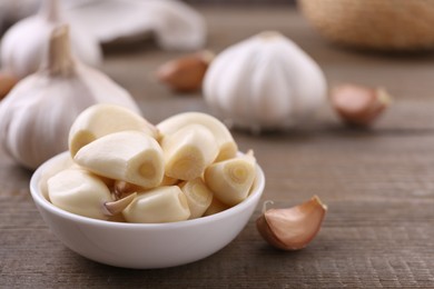 Aromatic garlic cloves and bulbs on wooden table, closeup. Space for text