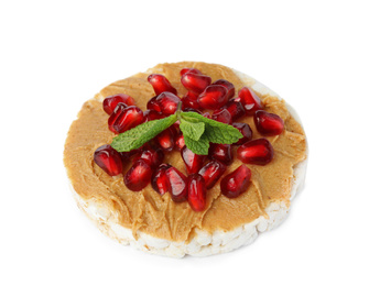 Puffed rice cake with peanut butter, pomegranate seeds and mint isolated on white