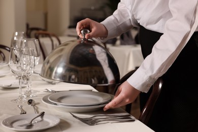 Photo of Woman setting table in restaurant, closeup. Professional butler courses