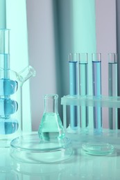 Laboratory analysis. Different glassware on table against color background