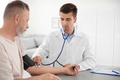 Photo of Doctor measuring patient's blood pressure in hospital