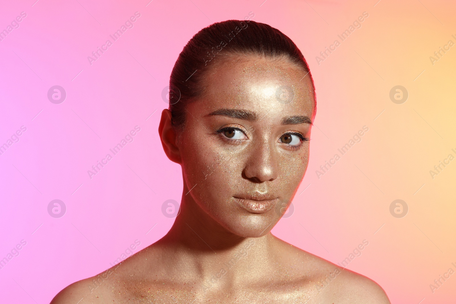 Photo of Beautiful young woman with glitter makeup on colorful background