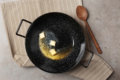 Photo of Flat lay composition of frying pan with melting butter on grey table