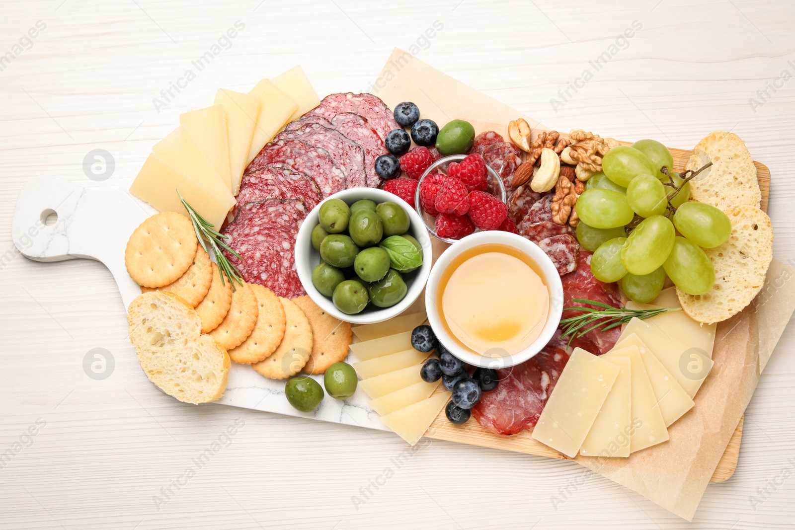 Photo of Snack set with delicious Parmesan cheese on light wooden table, top view