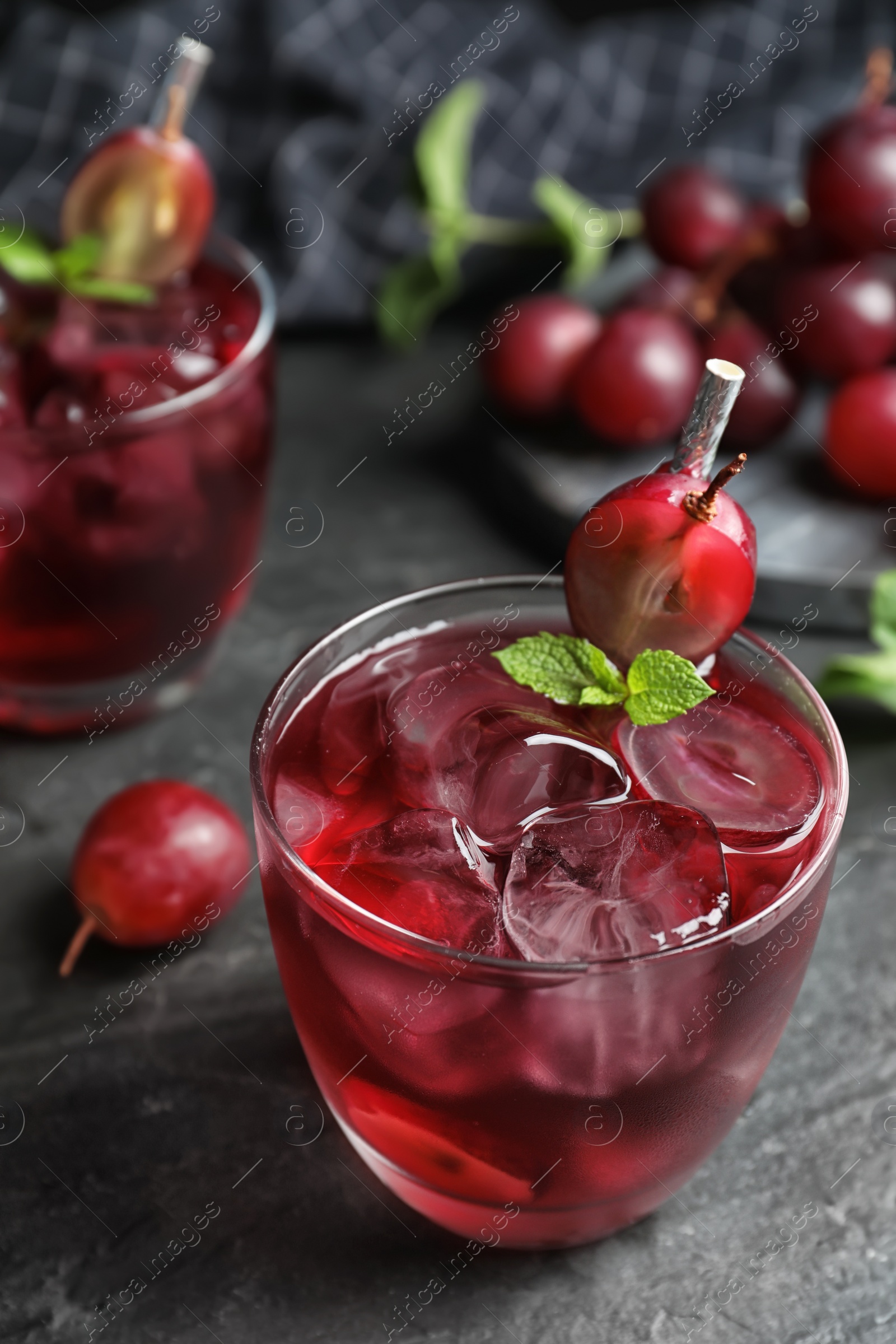 Photo of Delicious grape soda water on black table. Refreshing drink