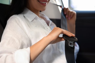 Photo of Woman pulling seat belt in car, closeup