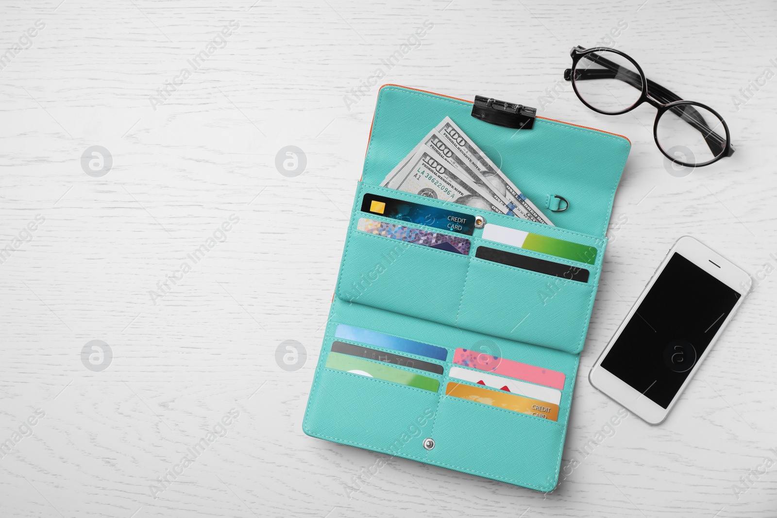 Photo of Smartphone, glasses and stylish wallet with cash and credit cards on light background, top view