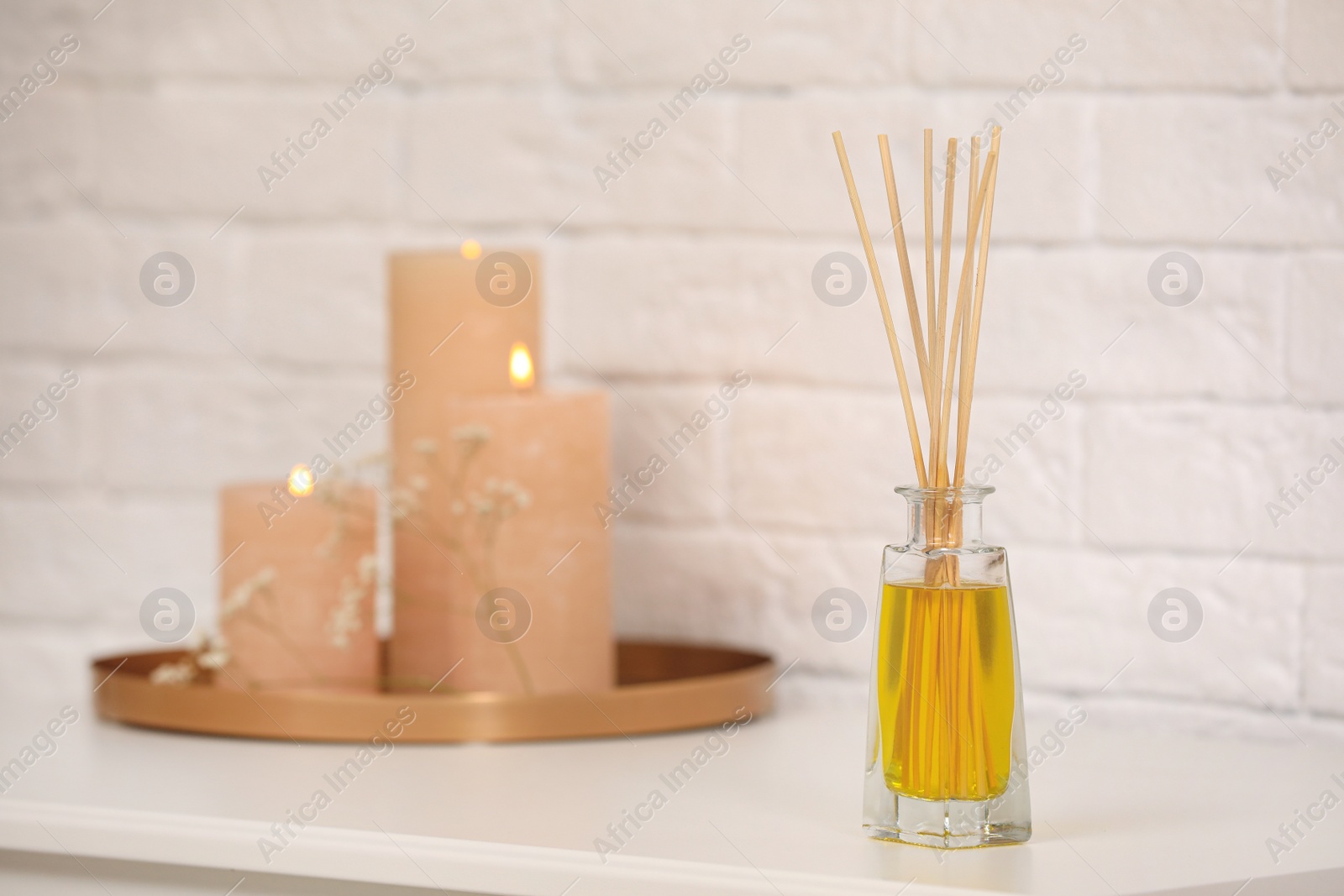 Photo of Reed air freshener with essential oil on table indoors. Space for text