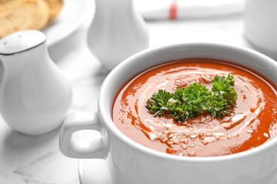 Dish with fresh homemade tomato soup on table, closeup. Space for text