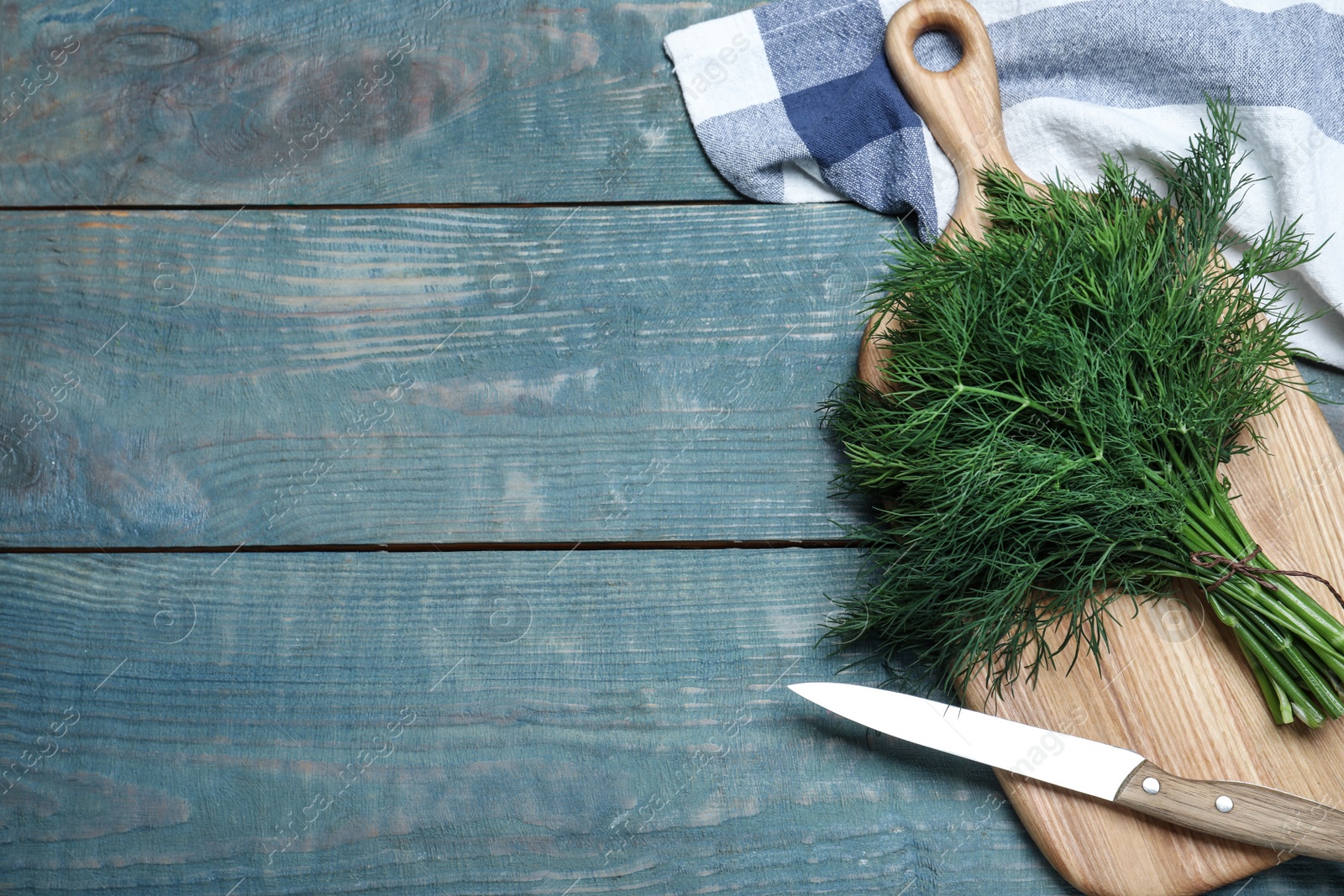 Photo of Bunch of fresh dill on light blue wooden table, flat lay. Space for text