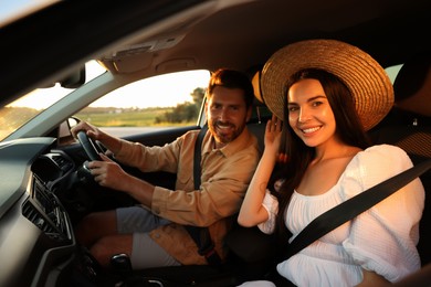 Happy couple enjoying trip together by car