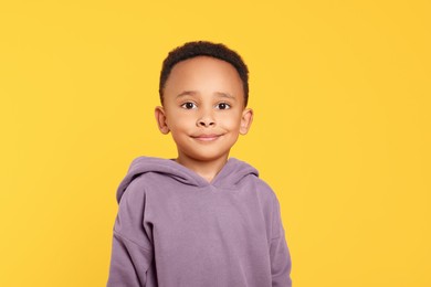 Photo of Portrait of cute African-American boy on yellow background