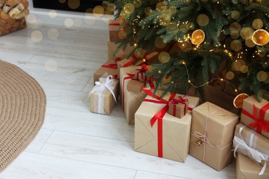 Many different gift boxes under Christmas tree in room, space for text