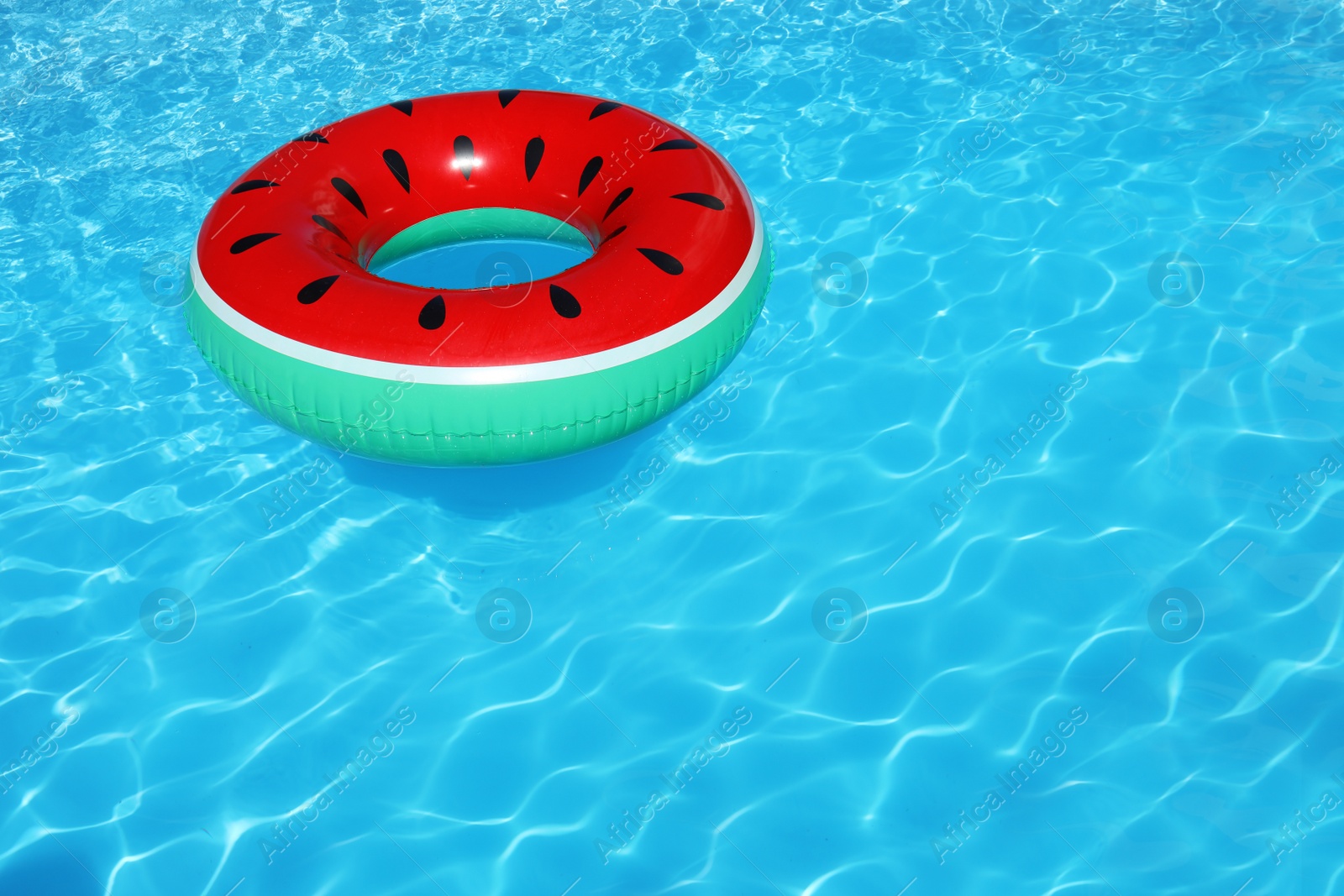 Photo of Inflatable ring floating in swimming pool on sunny day. Space for text