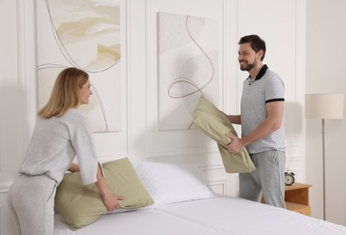 Couple changing bed linens at home. Domestic chores