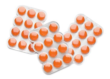 Photo of Blisters with orange cough drops on white background, top view