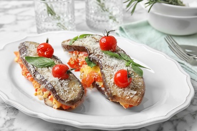 Photo of Baked eggplant with tomatoes, cheese and basil on plate