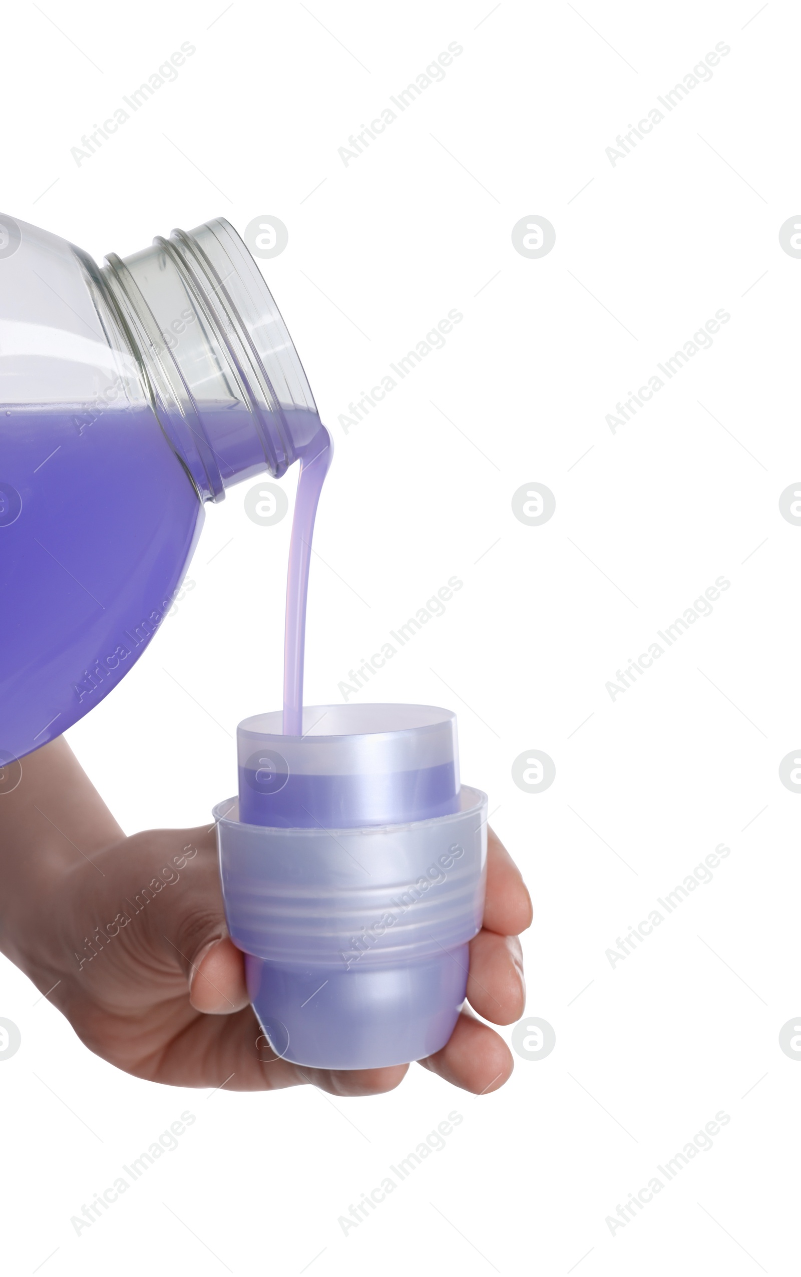 Photo of Woman pouring fabric softener from bottle into cap on white background, closeup