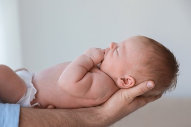 Photo of Father holding his newborn baby at home, closeup