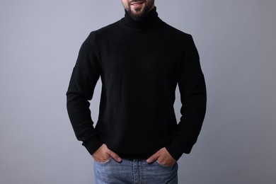 Photo of Man in stylish black sweater on grey background, closeup