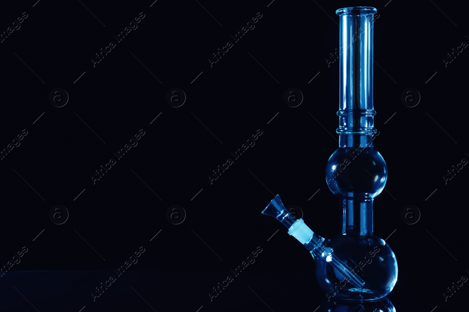 Photo of Glass bong on black background, space for text. Smoking device