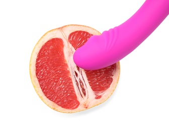 Half of grapefruit and purple vibrator on white background, top view. Sex concept