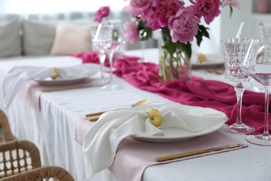 Beautiful table setting with pink peonies in dining room