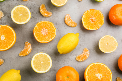 Photo of Flat lay composition with tangerines and different citrus fruits on grey background