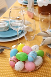 Festive table setting with painted eggs, glasses and cutlery. Easter celebration