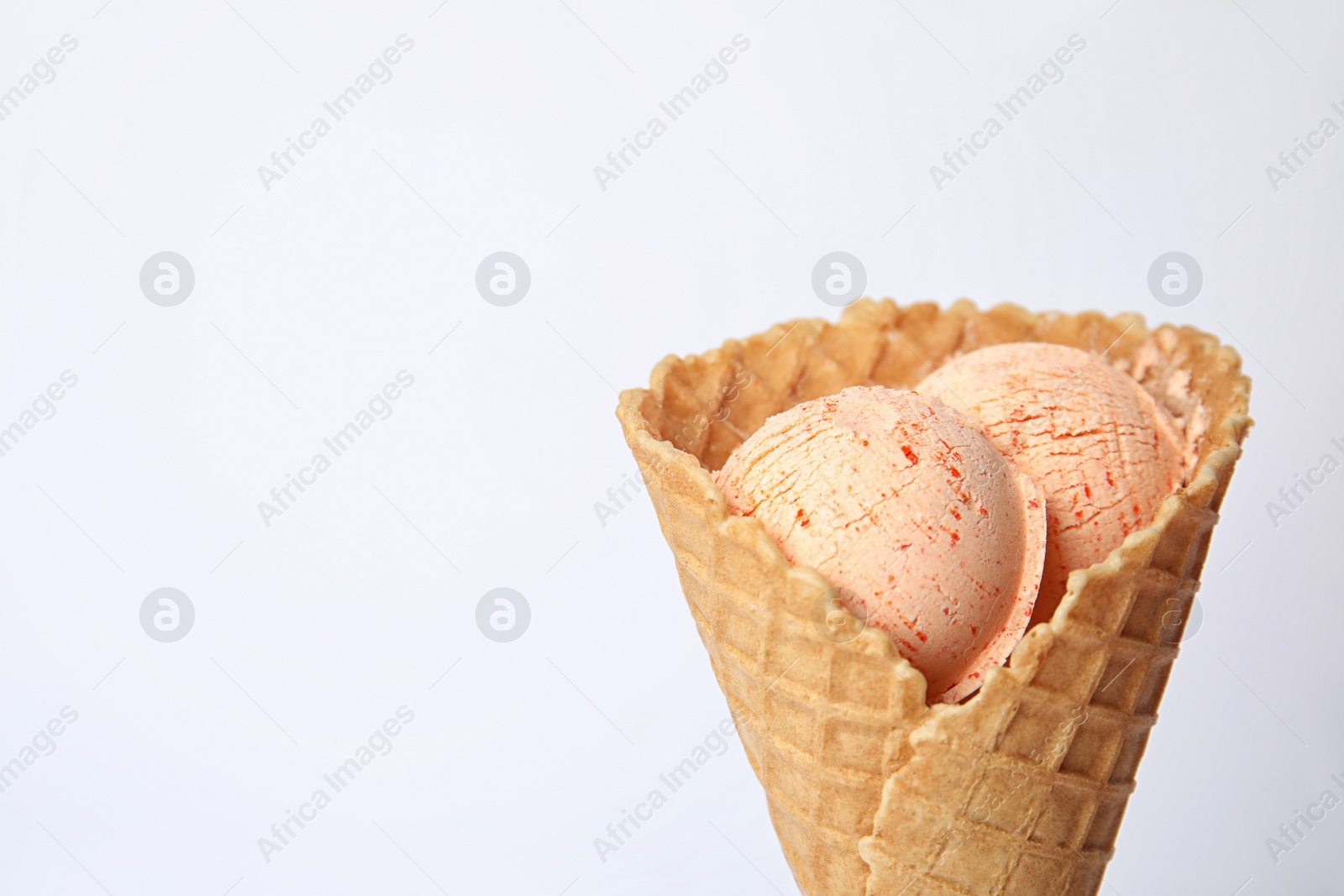 Photo of Delicious ice cream in waffle cone on white background