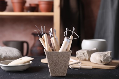 Clay and set of modeling tools on table in workshop